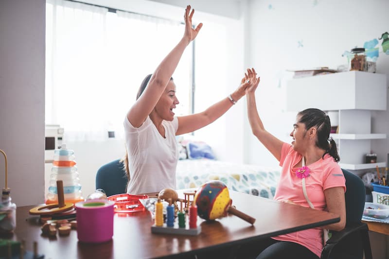 Teacher working with woman with Down Syndrome.