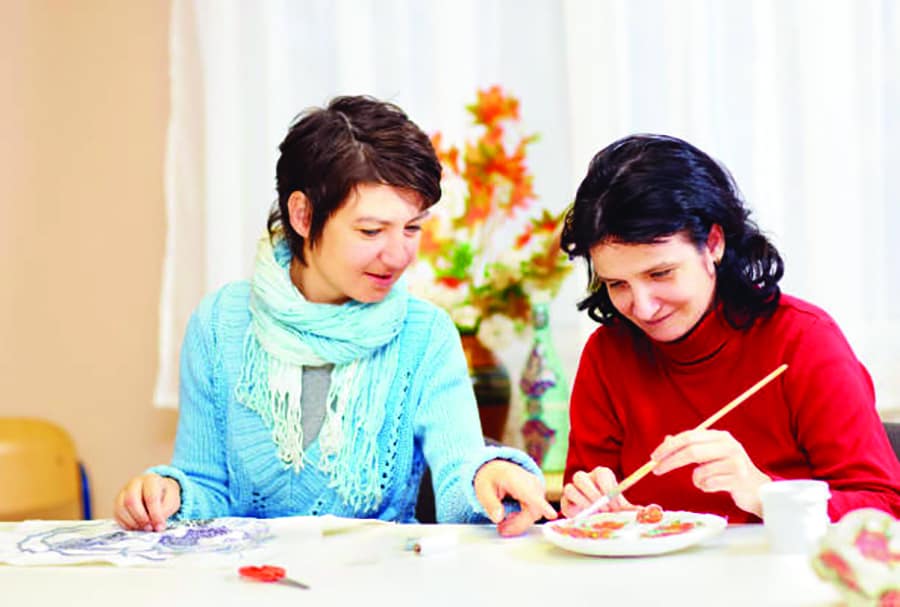 Two women work together on craft